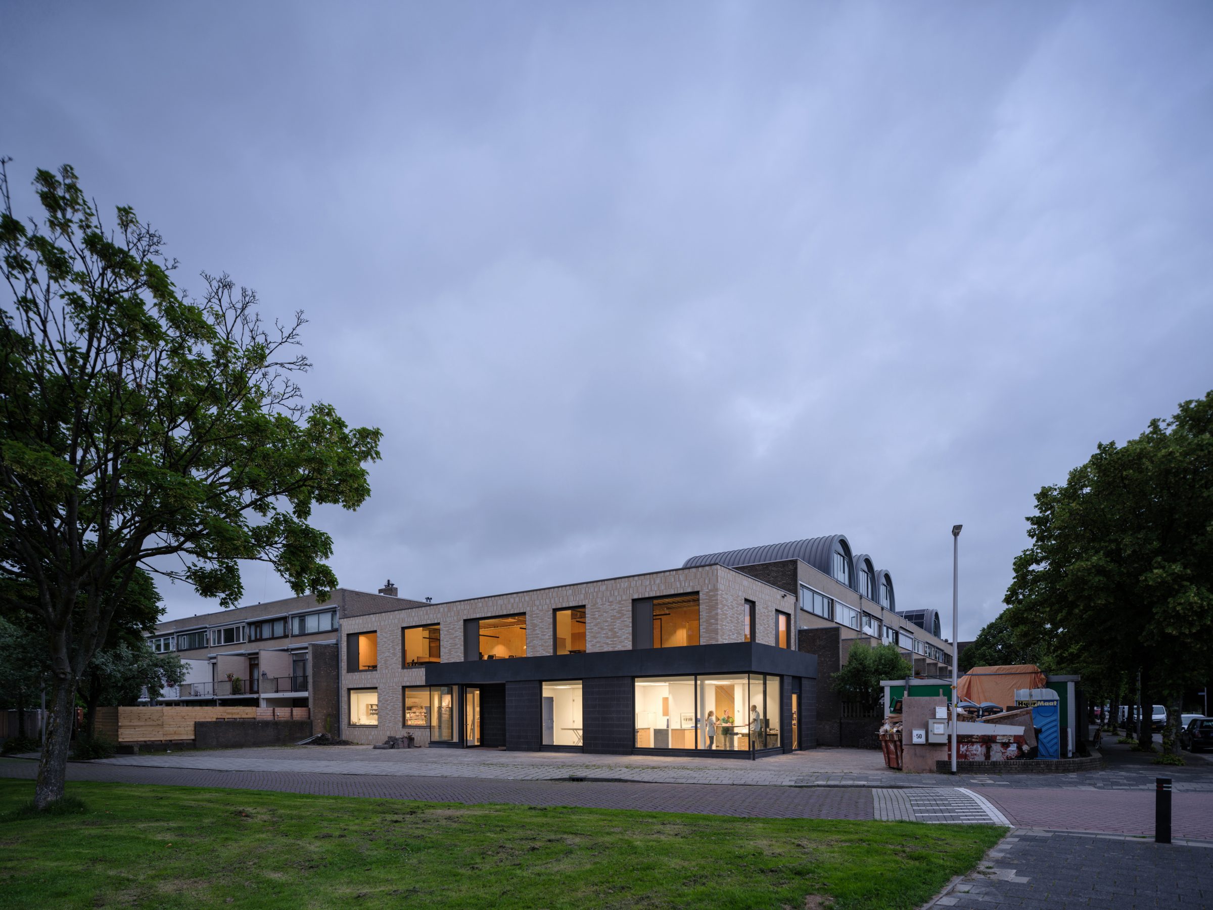 Corner building with glass corner aluminum window frames on ground floor extension. Light colored brick on CLT wood wall and new entrance to veterinary clinic. Veterinary clinic design for Anicure ‘t Leidse Land in Leiderdorp, designed and built by MOST Architecture, Rotterdam