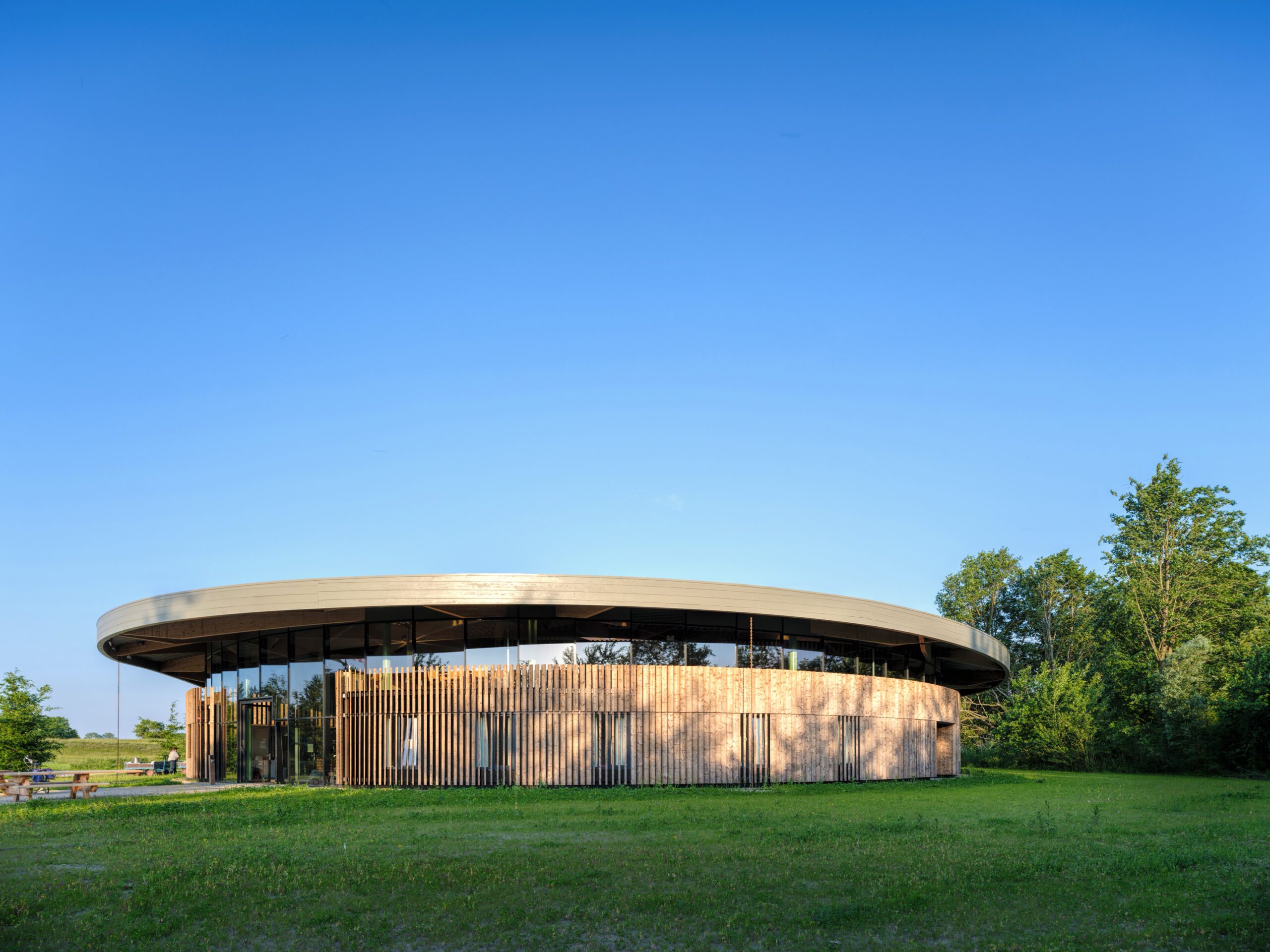 Wooden facade en curved laminated wooden roof structure of the Adventurehouse on the Socutinglandgoed Zeewolde a design by MOST Architecture Rotterdam
