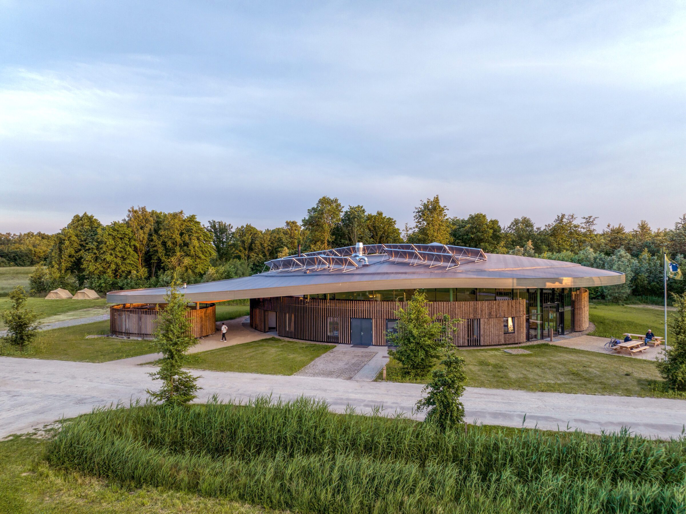 Curved roof elevation Avonturenhuis in the green natural surrounding designed and built by MOST Architecture