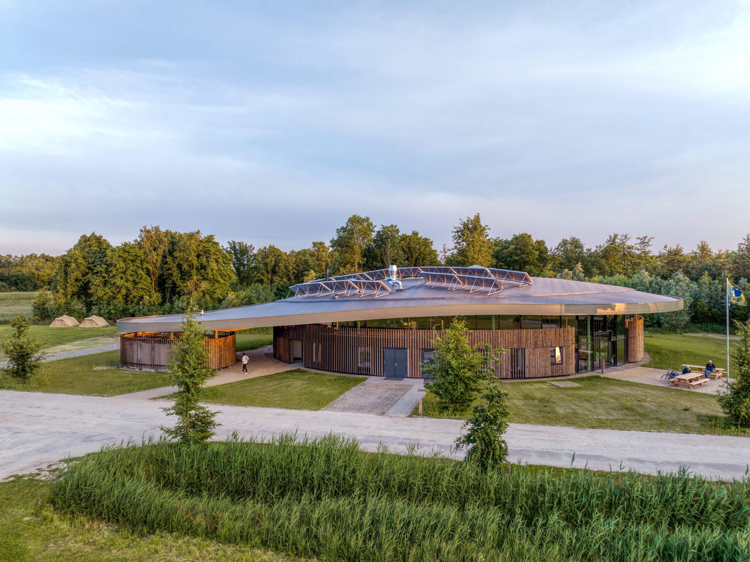Curved roof elevation Avonturenhuis in the green natural surrounding designed and built by MOST Architecture