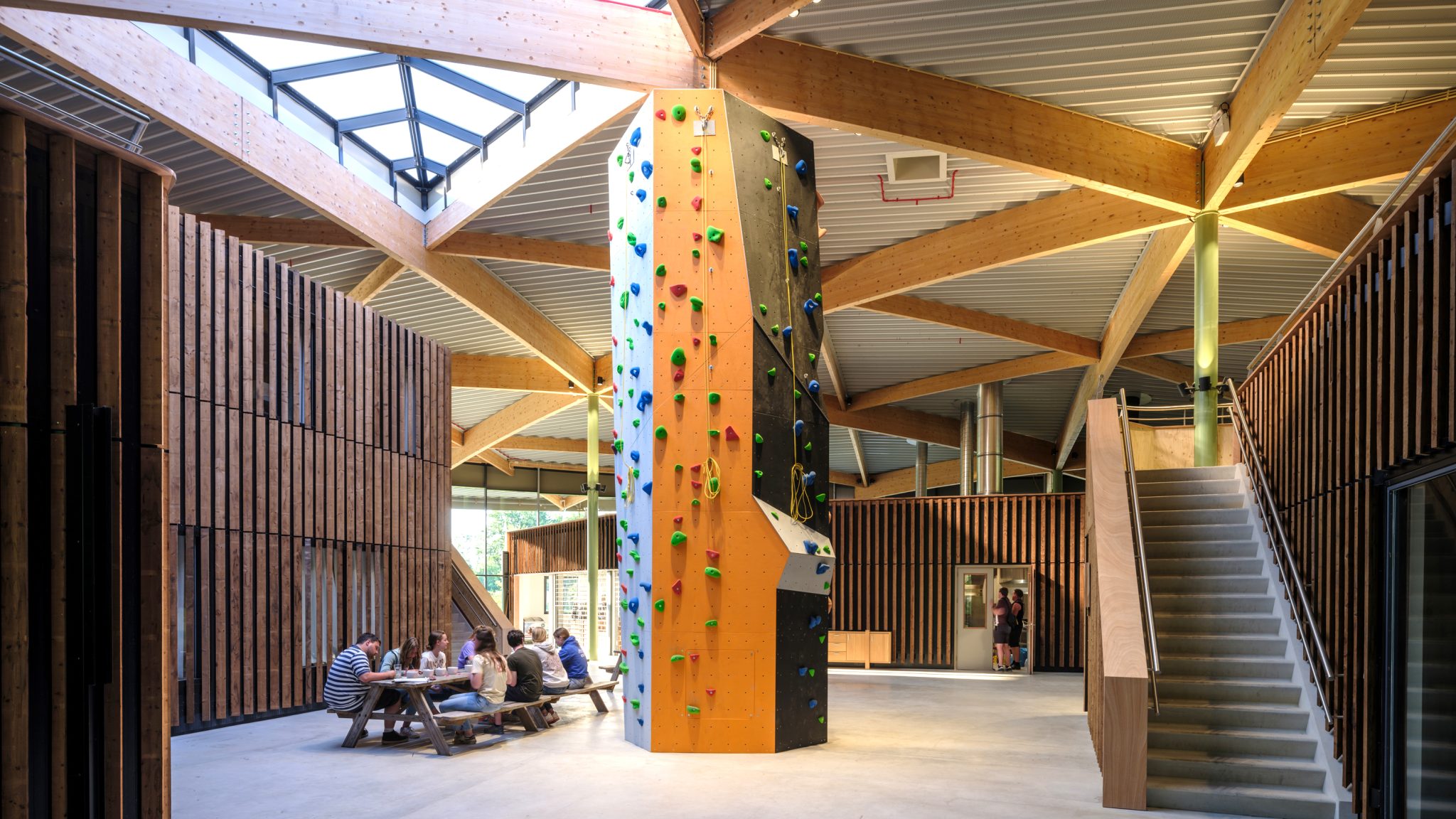 Interior space Avinturenhuis with climbing tower and wooden interior facade and laminated wooden curved beams designed and built by MOST Architecture