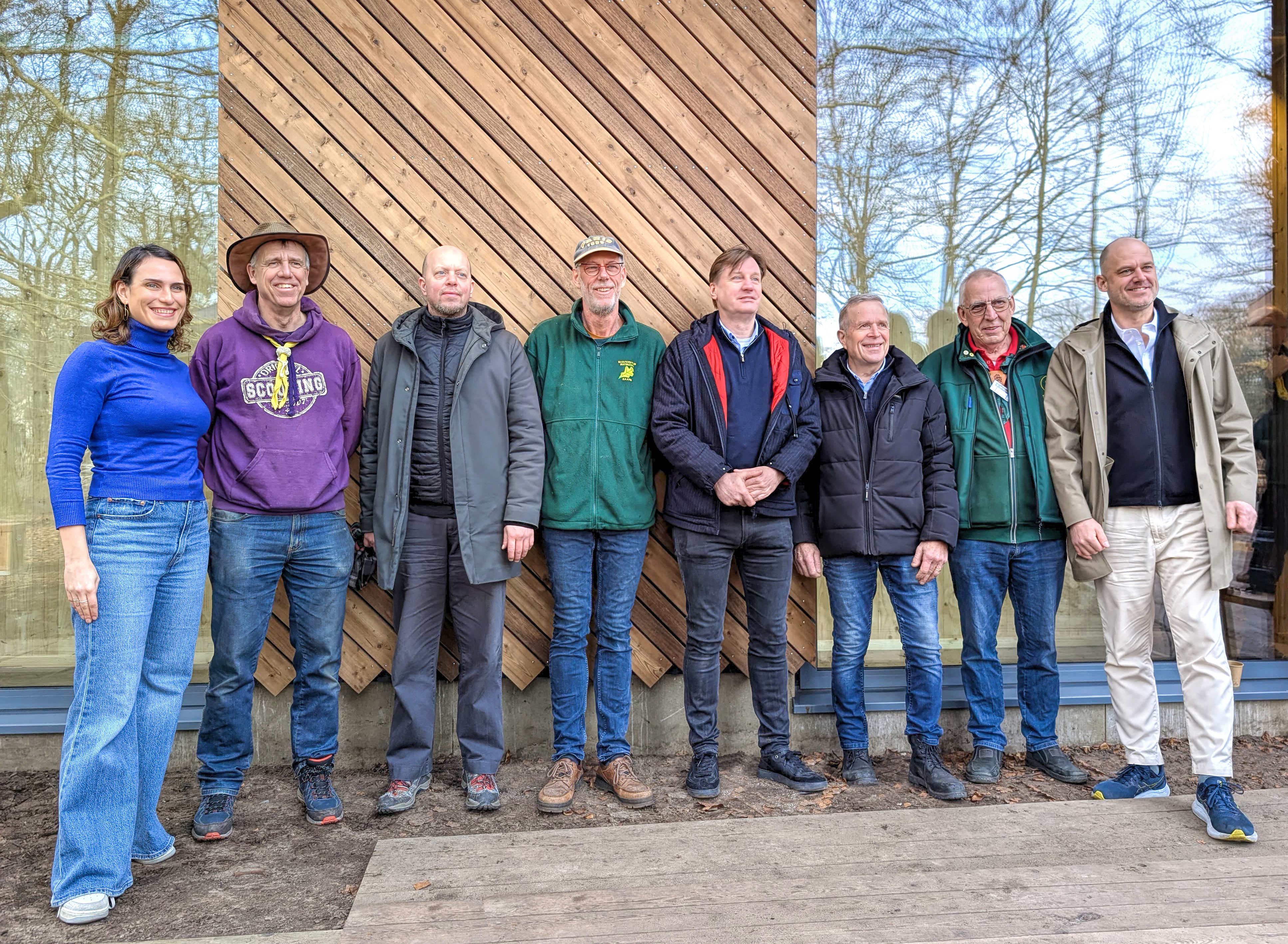 Het bouwteam tijdens de feestelijke opening van de Beverburcht en Vleermuizengrot op Scoutcentrum Buitenzorg, met burgemeester Mark Röell en Thijs Jansen. De biobased, duurzame en rolstoeltoegankelijke accommodaties, bieden ruimte aan 80 gasten en combineren innovatieve bouwprincipes met scoutingtraditie en natuur